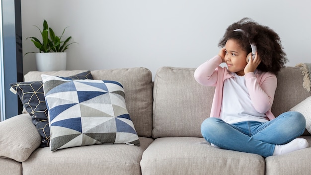 Free photo portrait of cute young girl listening to music