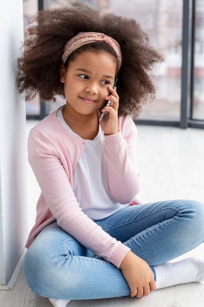 Portrait of cute young girl talking on the phone