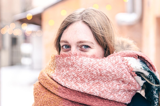 Портрет милой молодой женщины, завернутой в шарф зимой