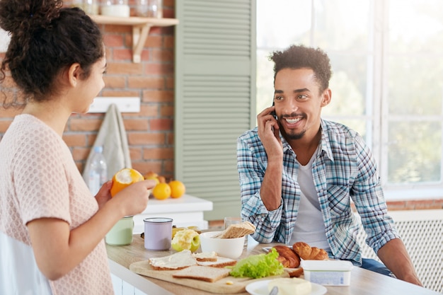 Portrait of dark skinned man has beard and mustache calls his friend