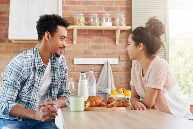 Portrait of dark skinned mixed race man visits his female friend, have pleasant conversation