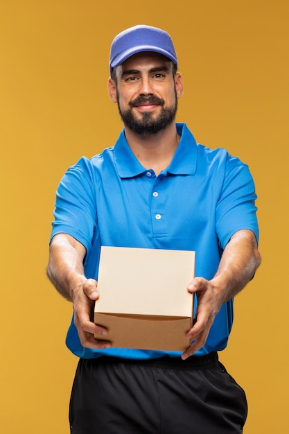 Free photo portrait of delivery man handing out parcel