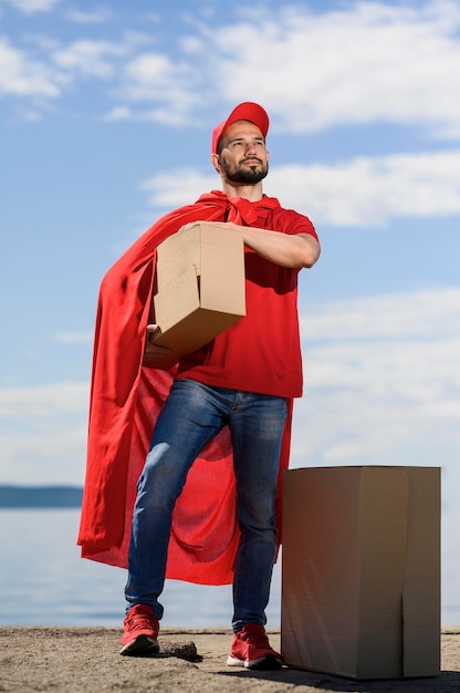 Free photo portrait of delivery man wearing superhero cape