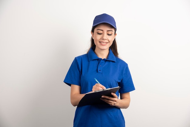 Free photo a portrait of a delivery young woman with clipboard . high quality photo