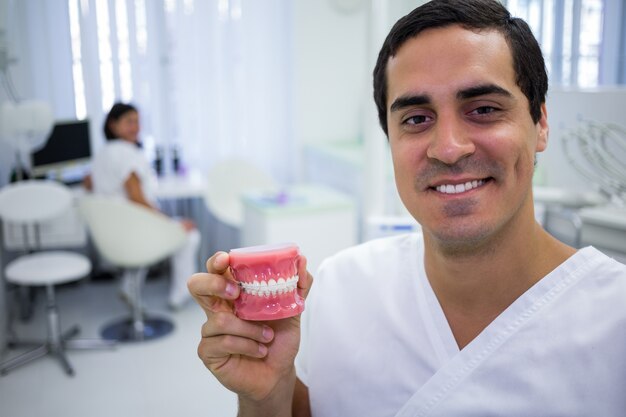 Portrait of dentist holding a set of dentures