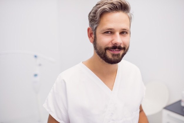 Foto gratuita ritratto del dentista che sta nella clinica