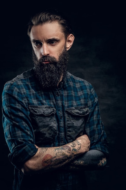 Portrait of depressed middle aged male in dark checkered shirt on the dark background.