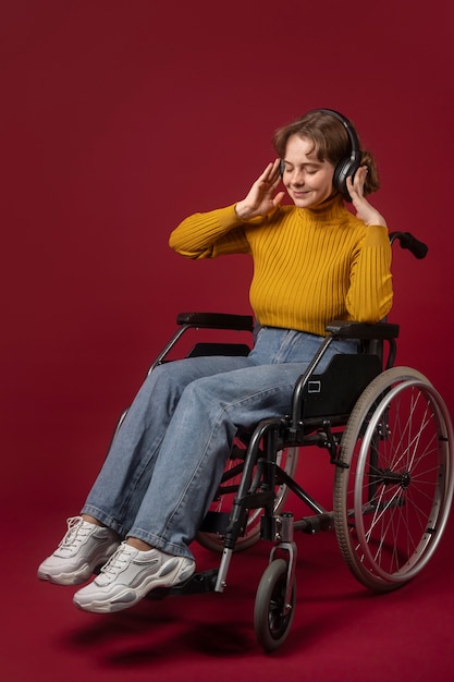 Портрет женщины-инвалида в инвалидной коляске с наушниками