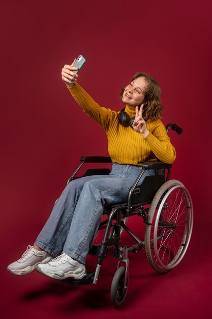 Portrait of disabled woman in a wheelchair with smartphone