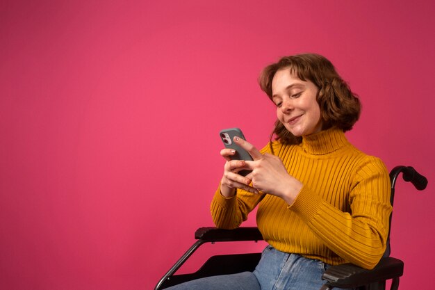 Portrait of disabled woman in a wheelchair with smartphone