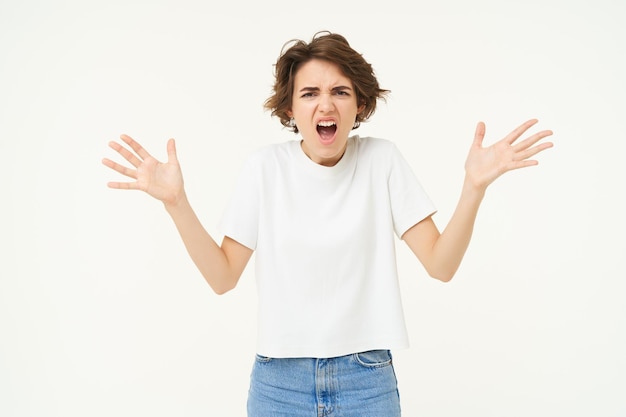 Portrait of disappointed upset young woman shaking hands shouting complaining shaking hands and