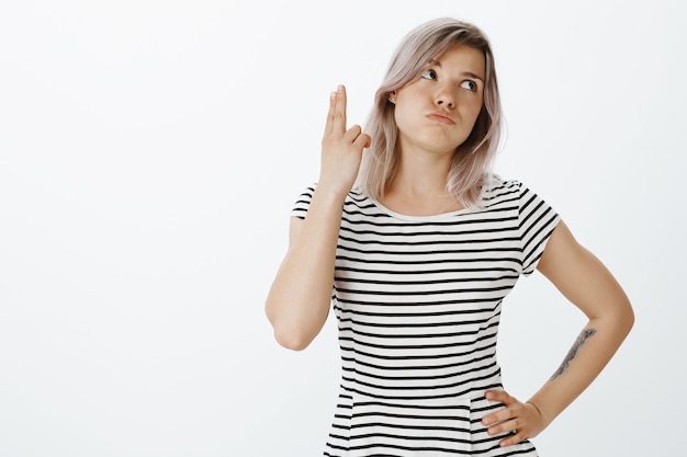 Portrait of displeased blonde girl posing in the studio