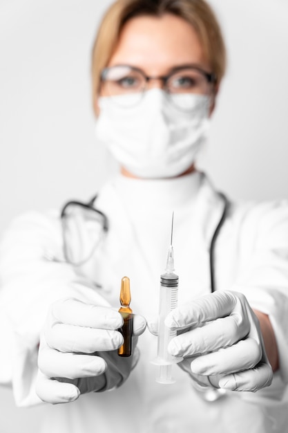 Portrait of doctor holding syringe with medical treatment