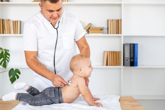 Free photo portrait of doctor listening little baby with stethoscope