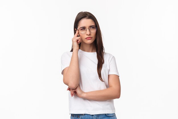 portrait of doubtful attractive brunette girl looking focused and suspicious