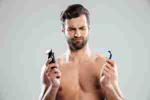 Free photo portrait of a doubtful young man choosing razor