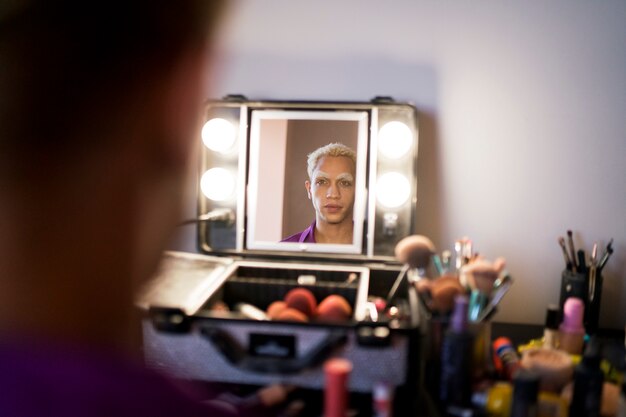 Portrait of drag man putting on makeup