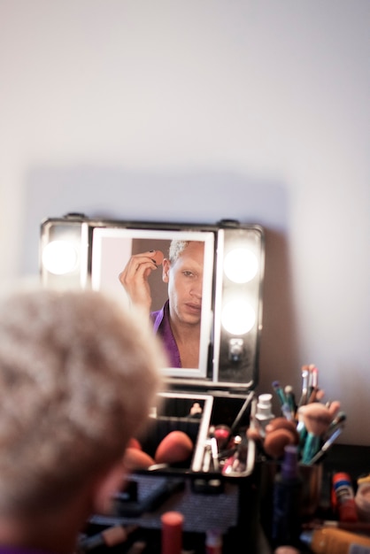 Portrait of drag man putting on makeup