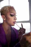 Free photo portrait of drag man putting on makeup