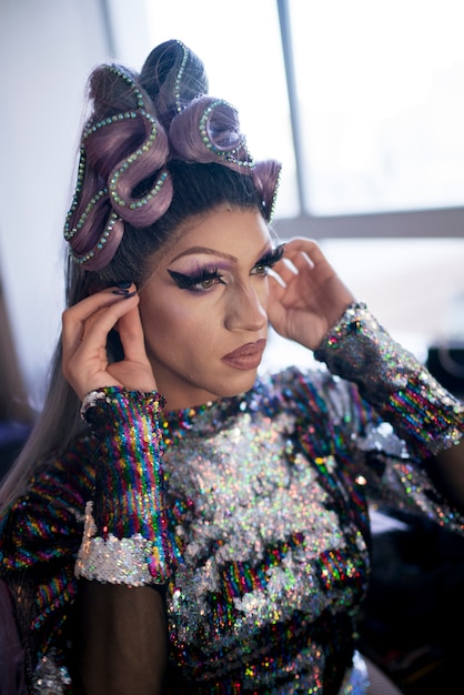 Portrait of drag man putting on makeup