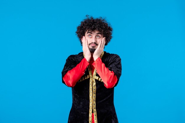 Portrait of dreaming azeri man in traditional costume studio shot blue background novruz spring ethnic dancer