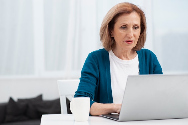 Foto gratuita ritratto di donna anziana con un computer portatile