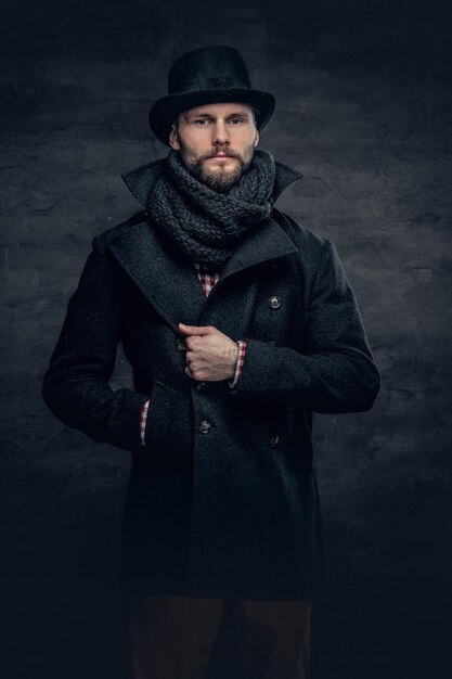 Portrait of an elegant bearded hipster man dressed stylish jacket and a cylinder hat.