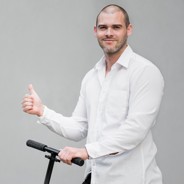 Free photo portrait of elegant male happy to ride scooter