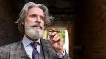 Free photo portrait of elegant male smoking cigar