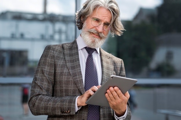 Portrait of elegant mature male browsing tablet