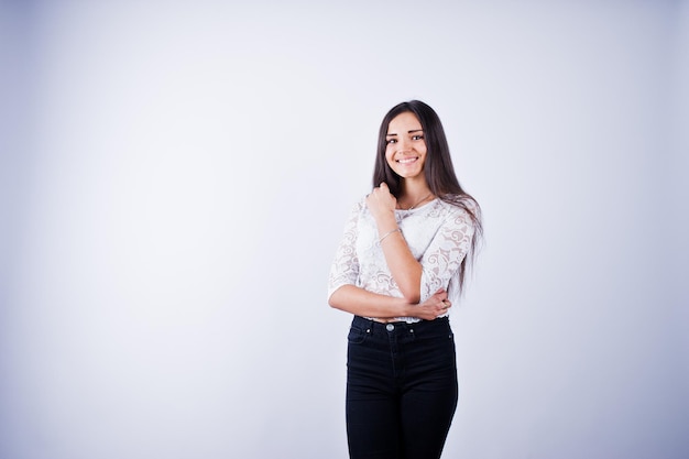 Portrait of an elegant young woman in white top and black pants in the studio