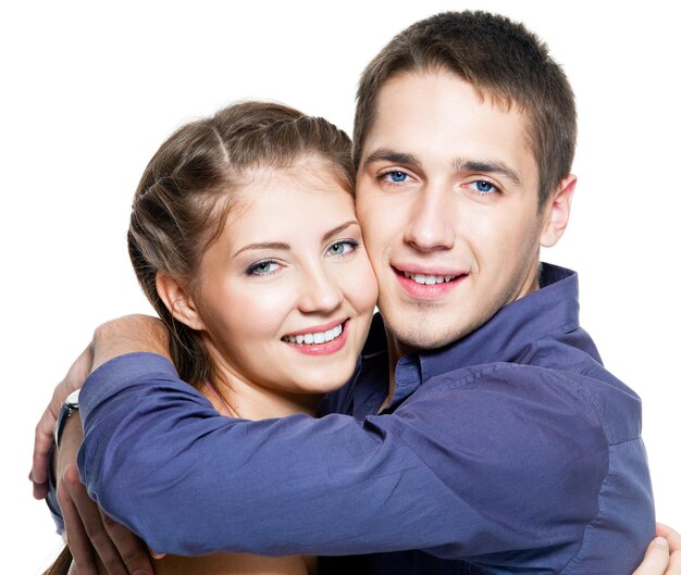 若い幸せな美しいカップルを抱きしめる肖像画-白い壁