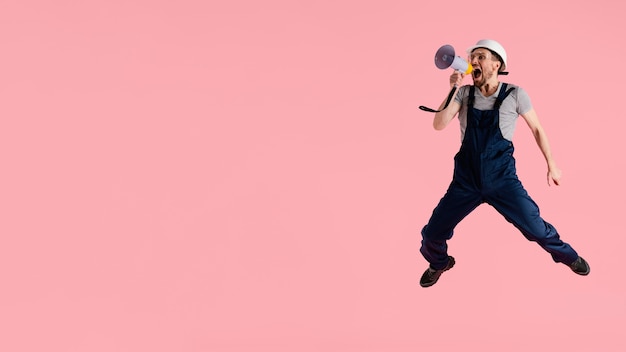 Free photo portrait engineer man jumping with megaphone