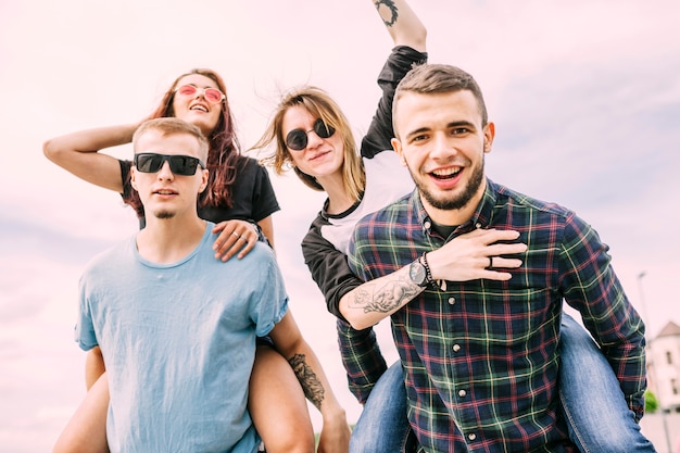 Portrait of enjoyable friends against blue sky