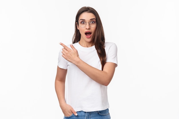 portrait of enthusiastic, amazed and impressed young attractive girl in glasses talking