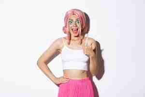 Free photo portrait of enthusiastic attractive female model with pink hair and party makeup