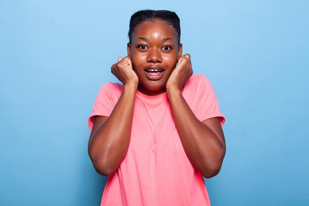 Portrait of excited african american young woman smiling at camera laughing