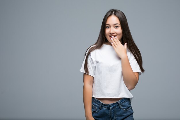 Portrait of an excited asian woman looking at camera over gray background