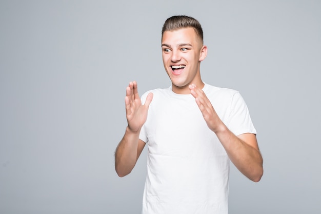 Portrait of an excited boy man holding arms on his head isolated on white