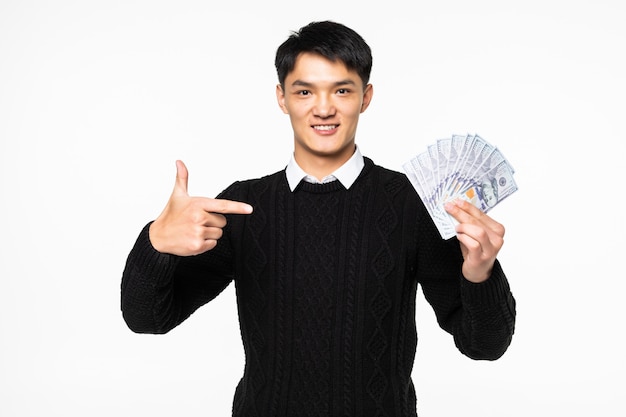 Free photo portrait of excited chinese man pointe on many banknotes isolated on white wall