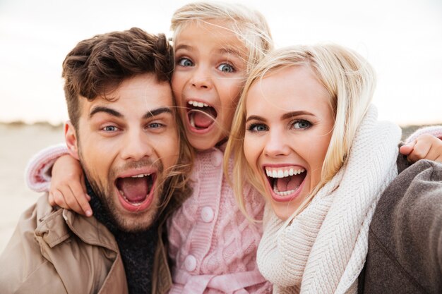 Portrait of an excited family with a little daughter