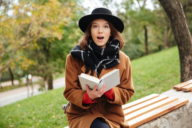 Free photo portrait of an excited girl dressed in autumn clothes reading