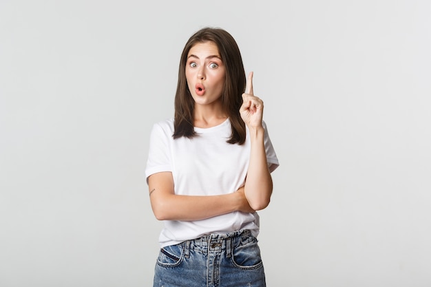 Portrait of excited girl raising finger, have suggestion or thought