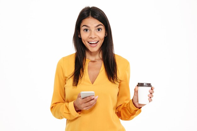 Portrait of excited happy woman holding mobile phone