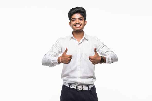 Portrait of excited man in formal wear giving thumbs-up against white wall