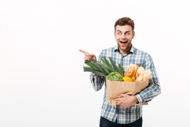 Portrait of an excited man holding paper bag