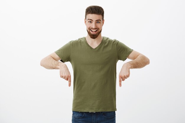 Portrait of excited man pointing down