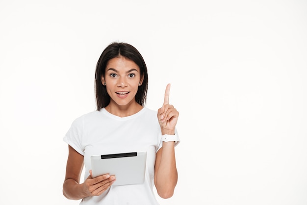 Portrait of an excited smart woman holding tablet