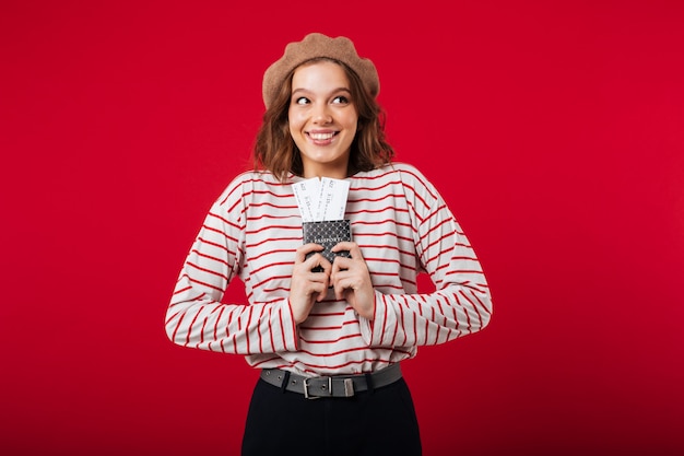 Portrait of an excited woman holding passport with flying tickets