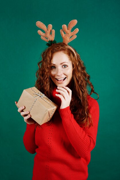 Portrait of excited woman opening christmas present